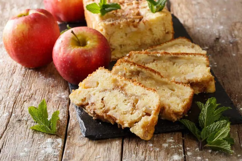 Sliced apple cake with apples on board