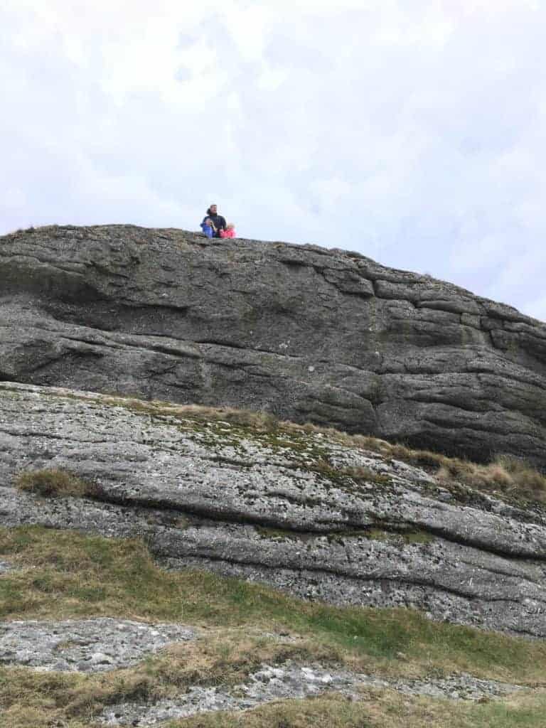 Family high on a rocky outcrop in Dartmoor National Park, Devon