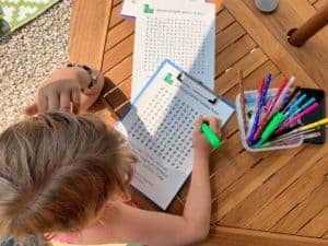 Child doing a word search - Devon themed printable activities for kids