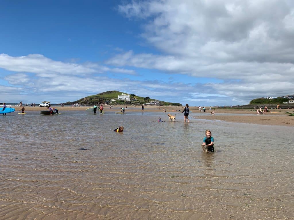 People enjoying Bigbury Beach with Burgh Island in the background