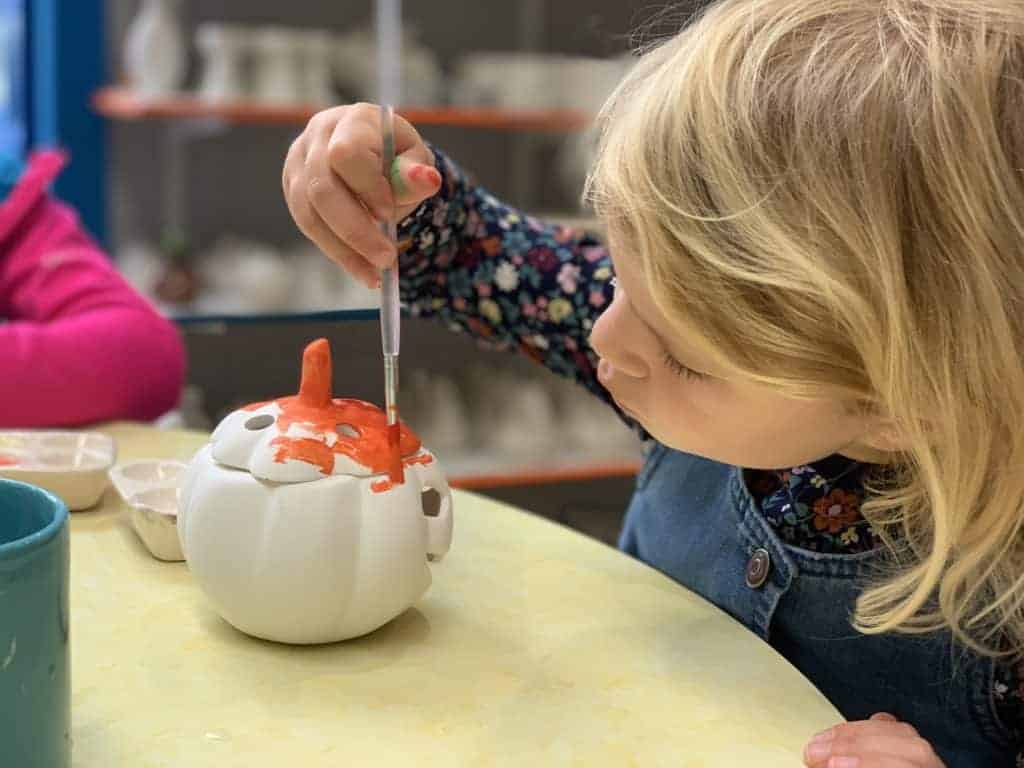 Child painting pottery at China Blue in Totnes