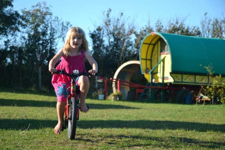 Child on bike at glamping site in Devon