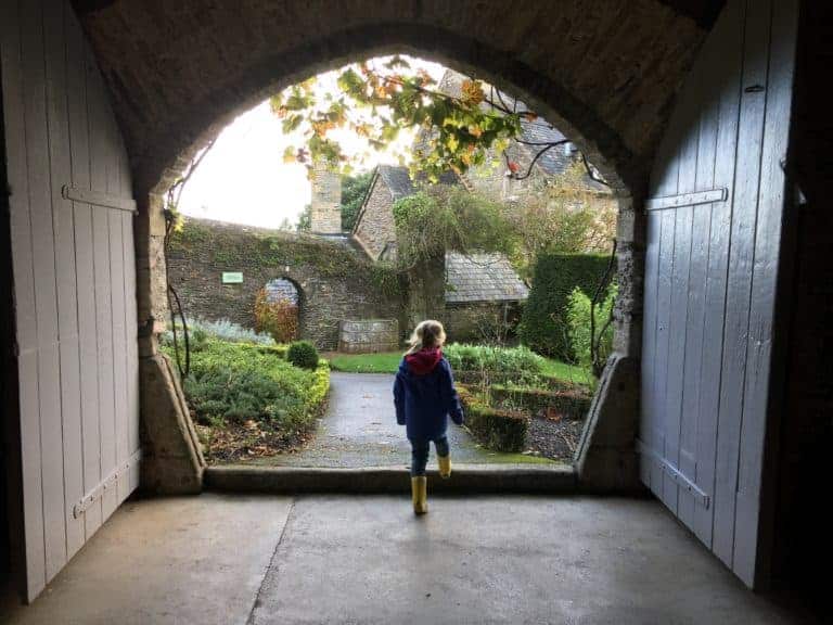Child walking through doorway into garden at Buckland Abbey in Devon