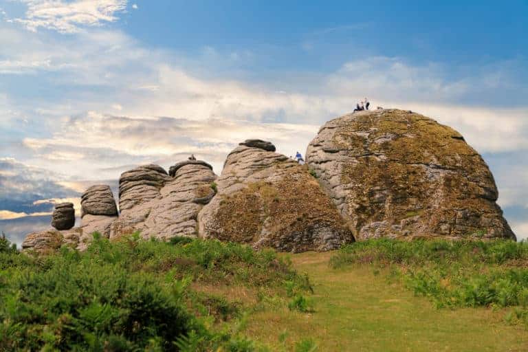 Families climbing a tor on Dartmoor in Devon, UK