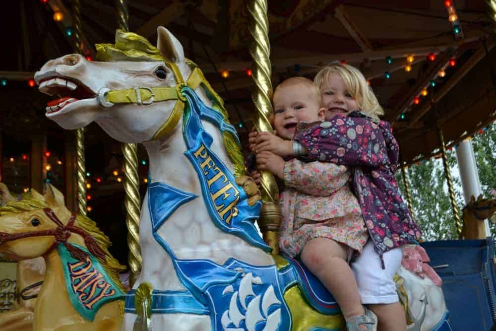 Girls on vintage horse carousel at Crealy