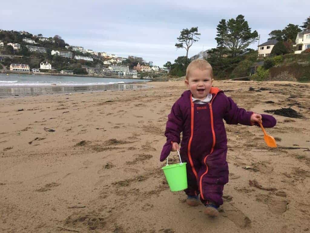 Toddler with bucket and spade on Mill Bay beach