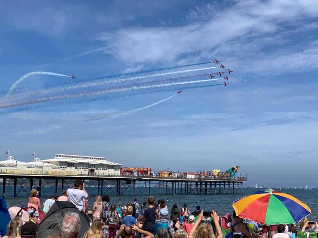 Red Arrows flying over Paignton Pier and beach in Devon