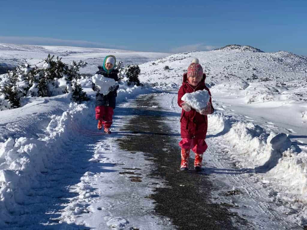 Children walking with blocks of snow on Dartmoor, Devon in Winter