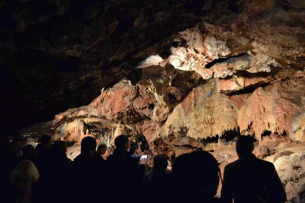 People silhouetted against the Rocky Chamber in Kents Cavern