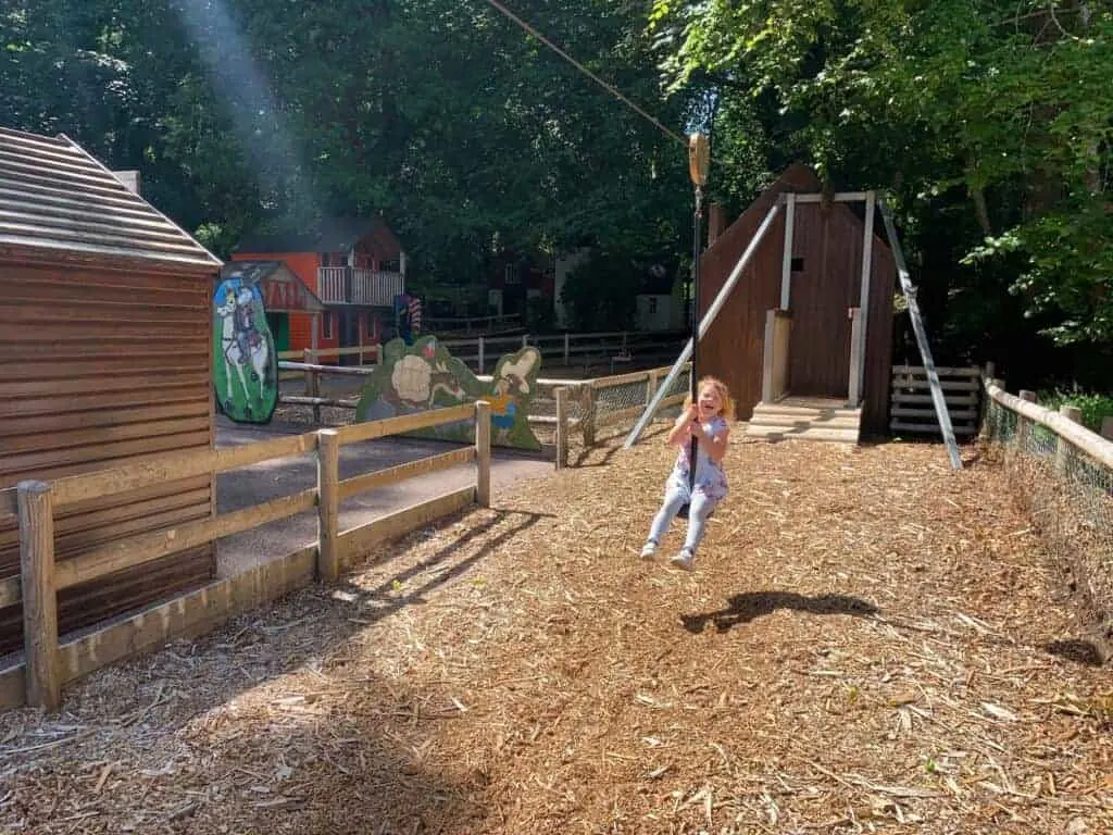Child riding zip line in adventure playground