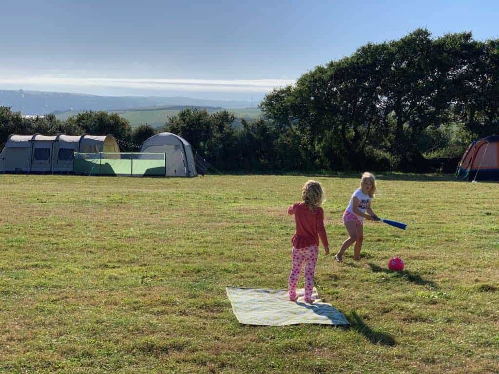 Children playing ball game on campsite field