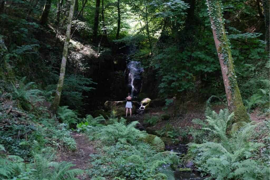 Teen standing in front of a waterfall in Devon