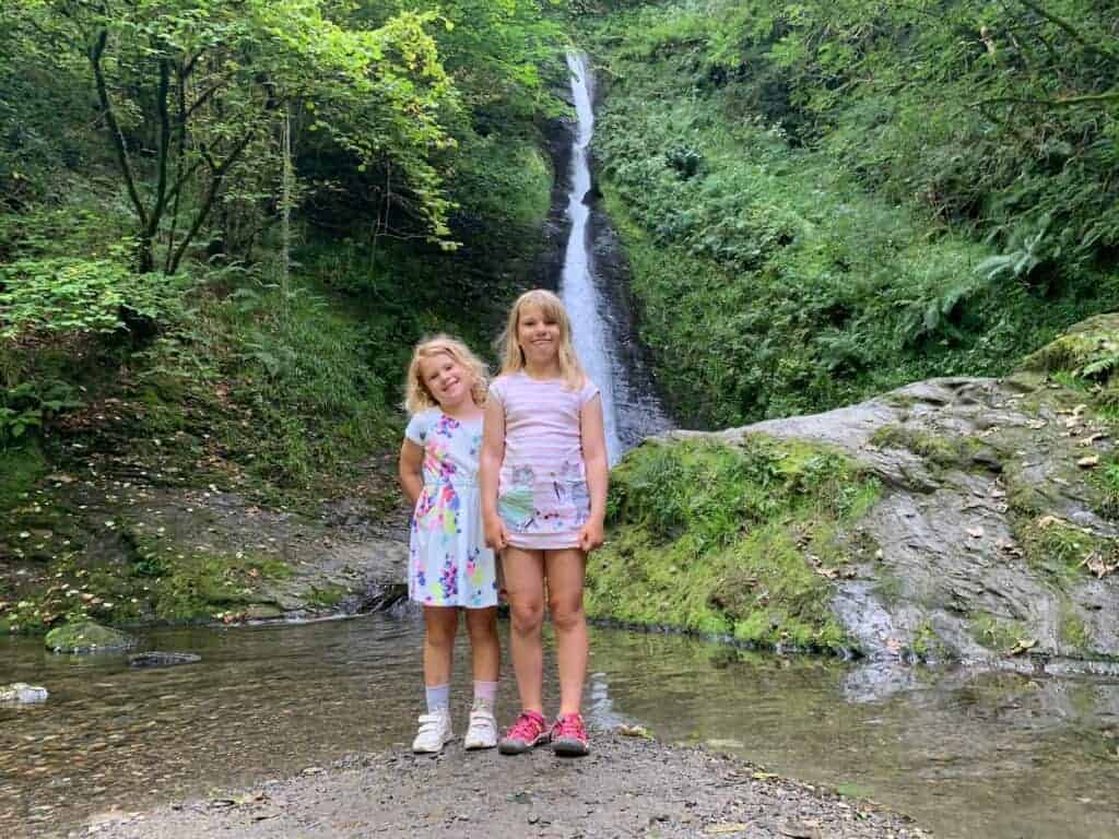 Kids standing in front of Whitelady Falls in Lydford Gorge
