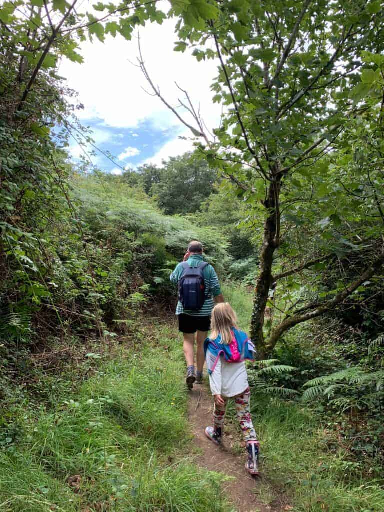 Family walking on tree lined footpath towards Rickman Common