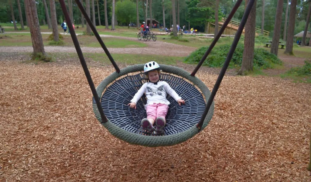Child in bucket swing at Haldon Forest Park