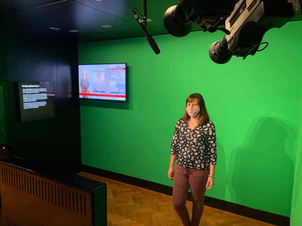 Helen from Twins, Tantrums and Cold Coffee presenting BBC Spotlight against a green screen in the Media Lab