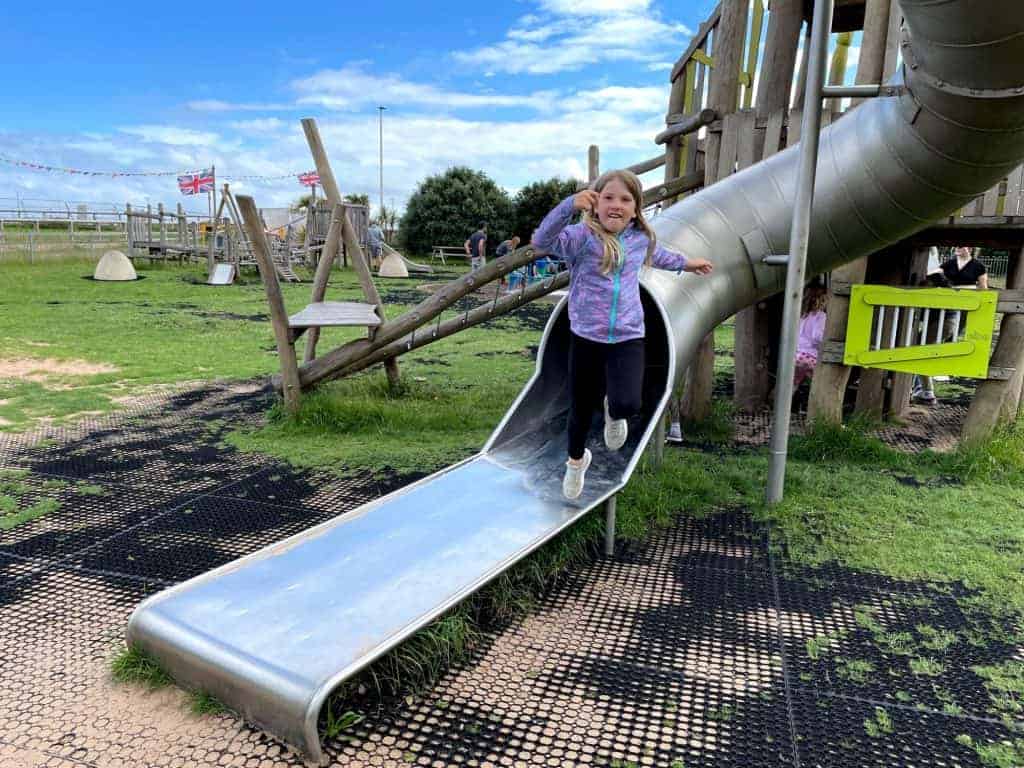 Child jumping off slide at Queens Drive Space adventure playground in Exmouth