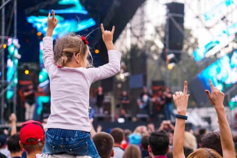 Kid on adult's shoulders at festival
