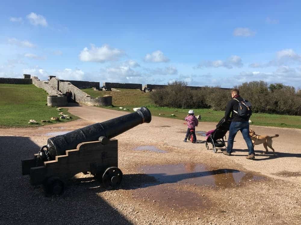 Family walking past a canon in fort 2 at Berry Head