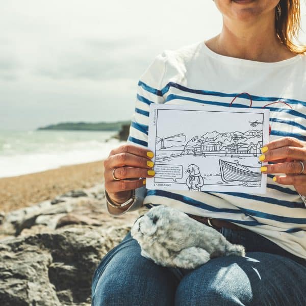 Torcross colouring page being held up against the same view