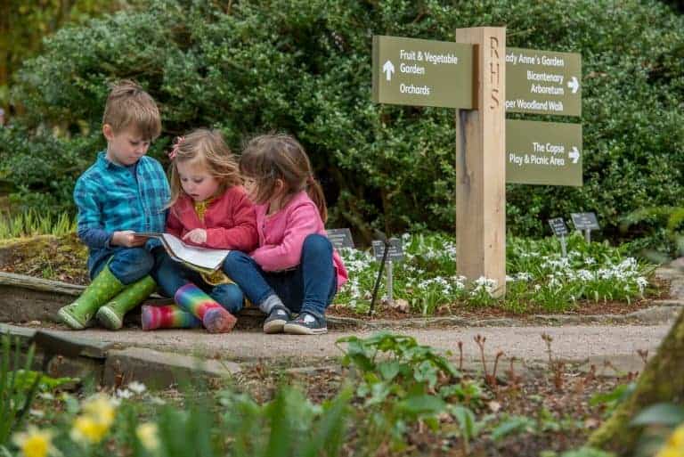 Credit: RHS GARDEN ROSEMOOR. Pictured are children on the spring trail looking at a trail map