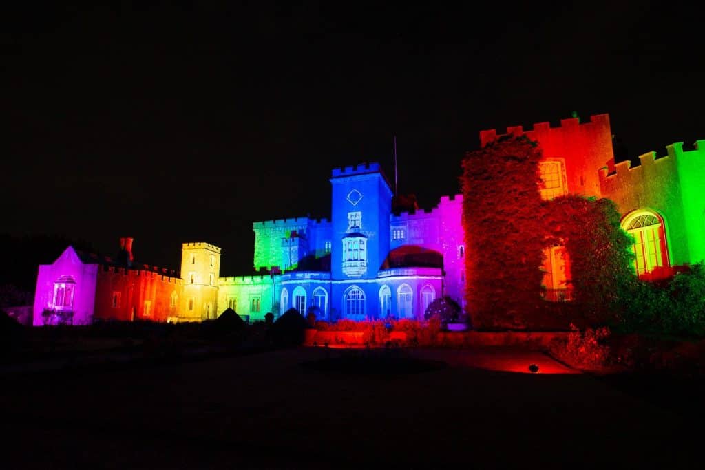 Powderham Castle illuminated with rainbow lights