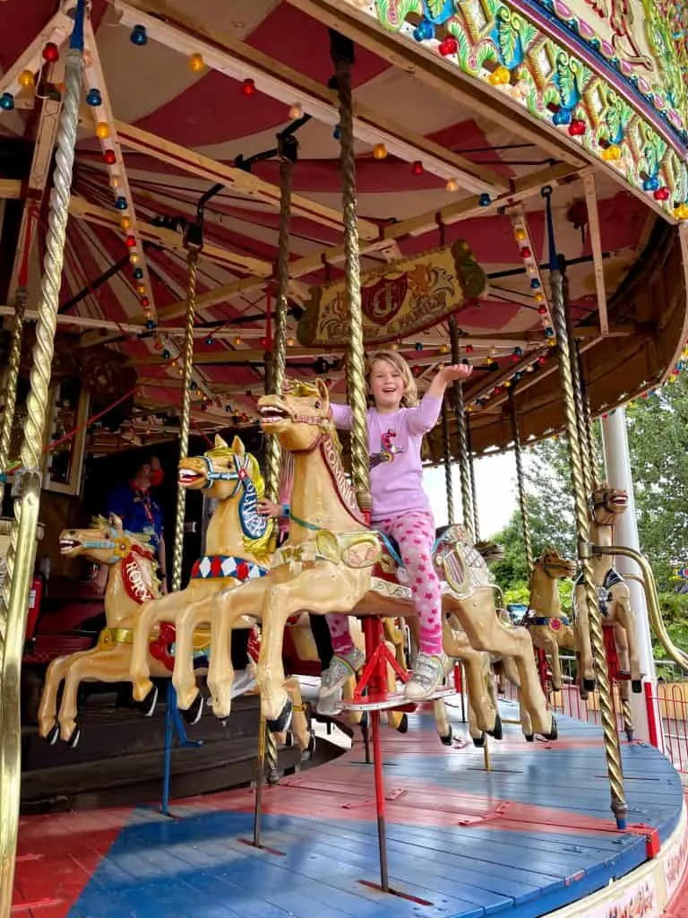 Girl sat on vintage carousel