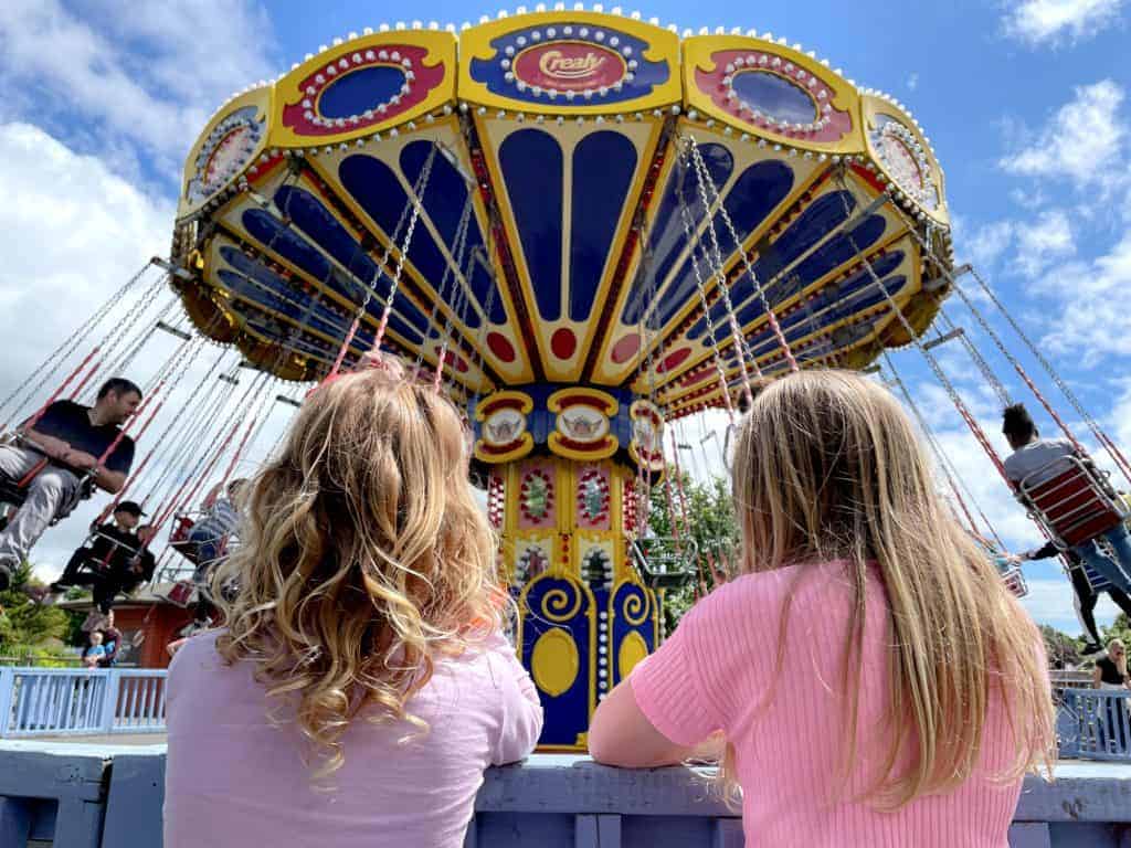 Girls standing in front of Flying Machine ride at Crealy Adventure Park