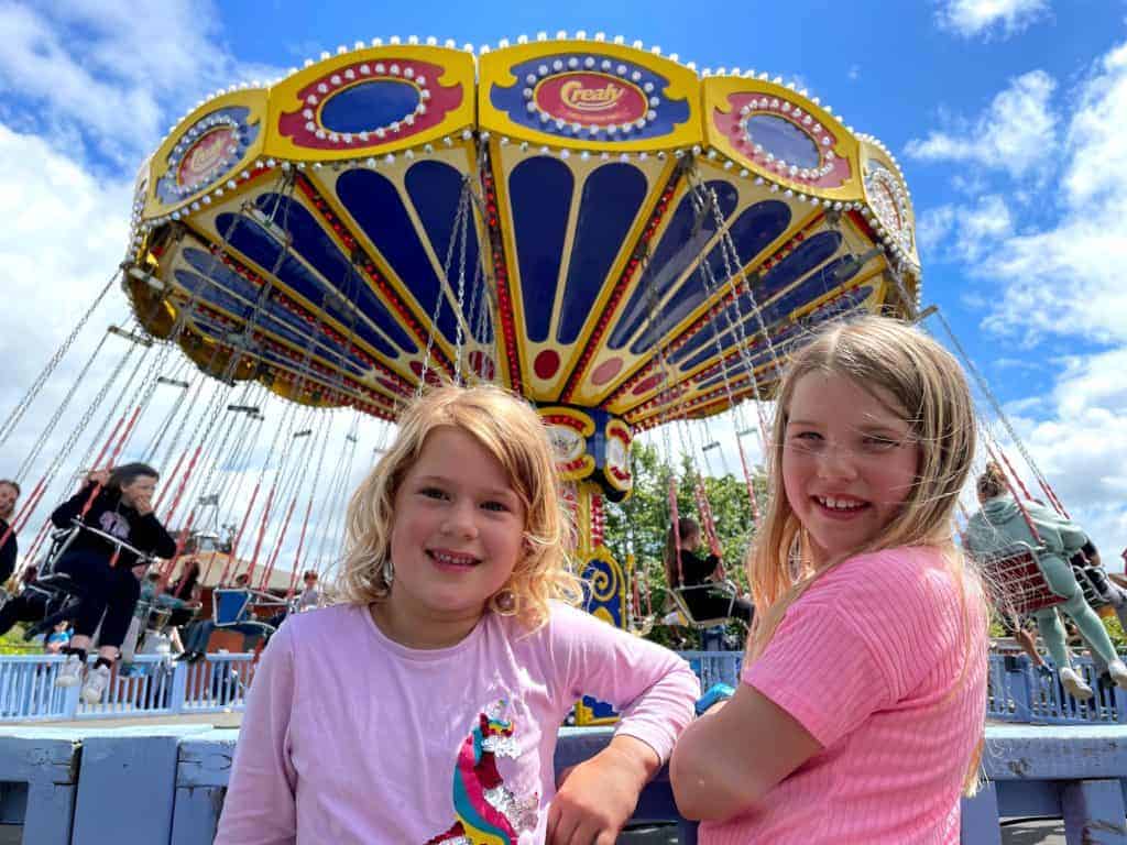 Girls standing in front of Flying Machine ride at Crealy Adventure Park