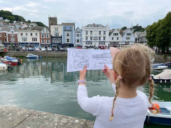 Child looking at Dartmouth colouring book in front of Boat Float