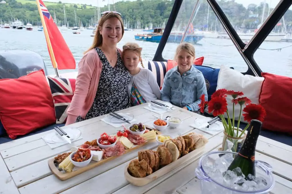 Family sat in boat with platters of food