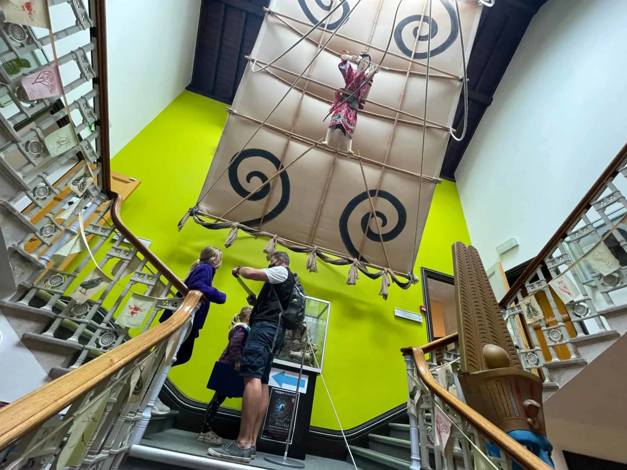 Family on stairwell at Torquay Museum under Japanese Man Kite