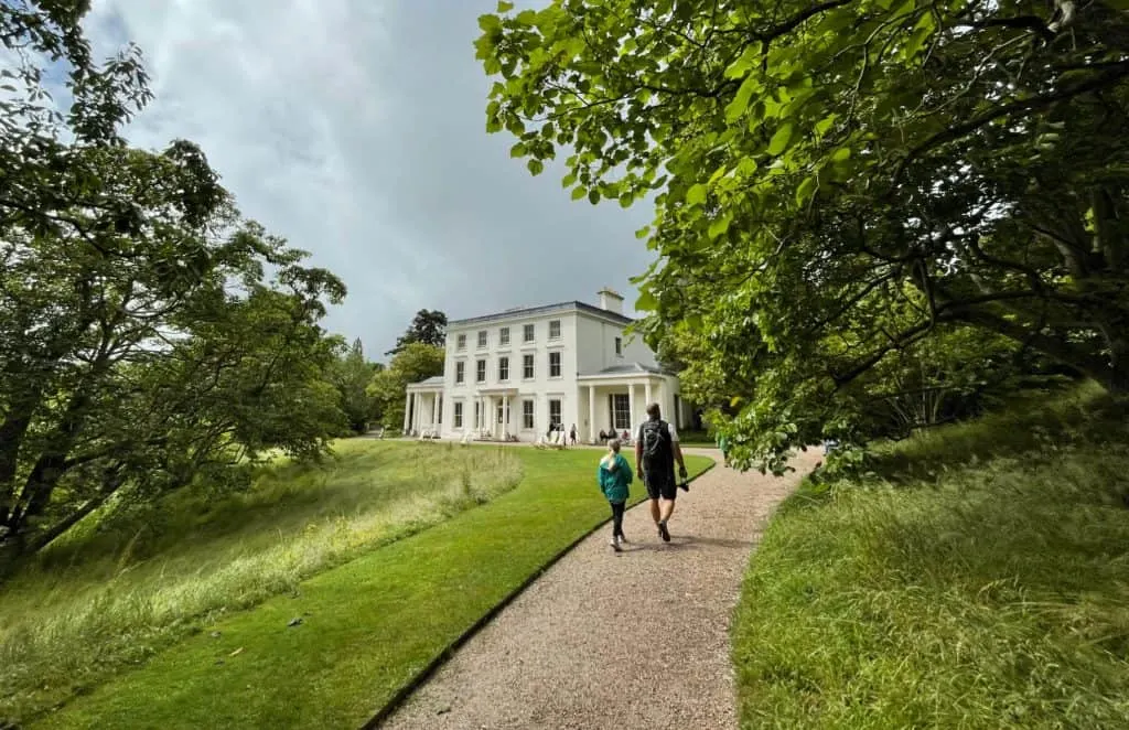Father and daughter walk towards Greenway House along footpath