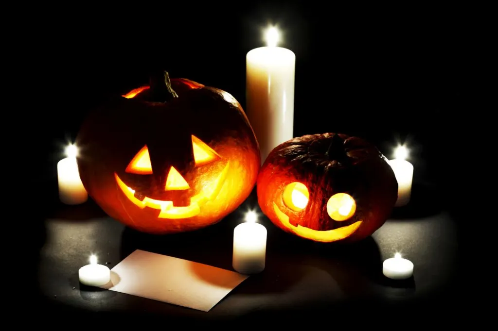 Pumpkin lanterns surrounded by candles