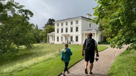 Father and daughter walk towards Greenway House along footpath