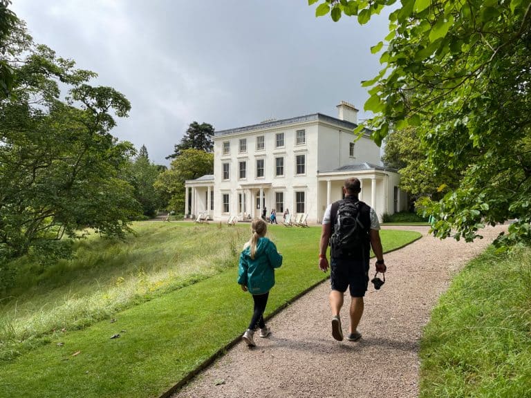 Father and daughter walk towards Greenway House along footpath