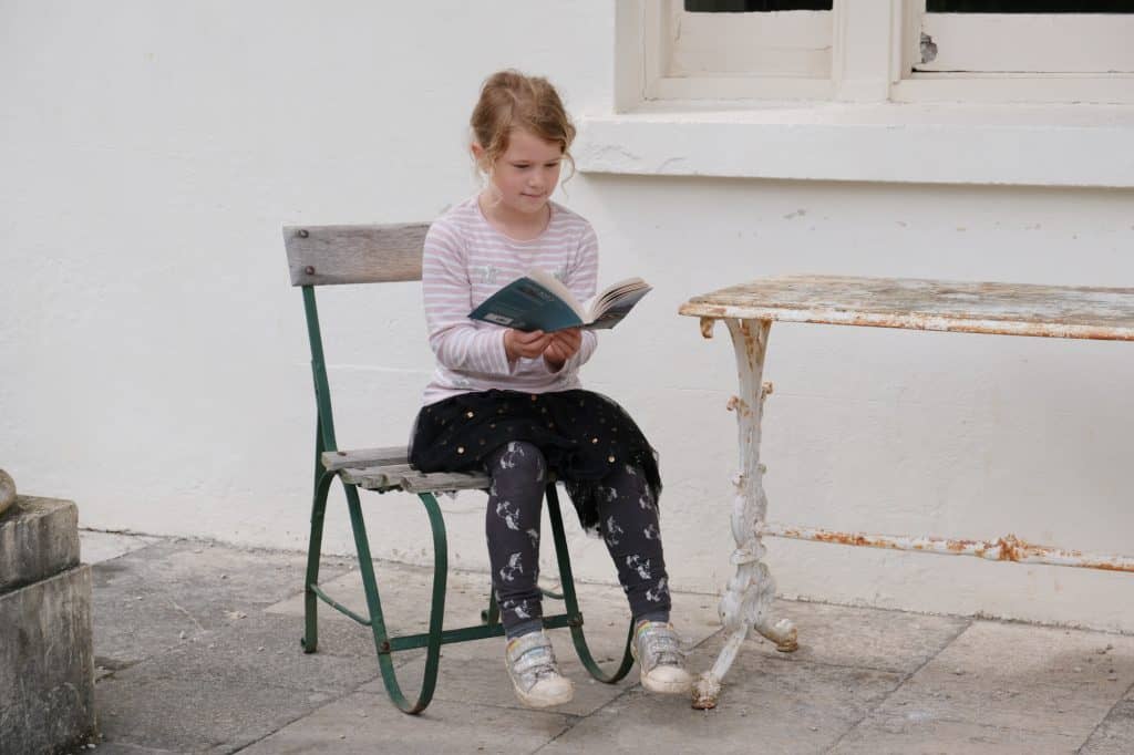 Child reading book outside Greenway House