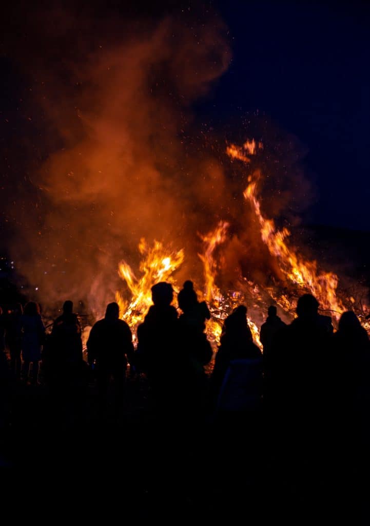 Silhouettes of people in front of bonfire