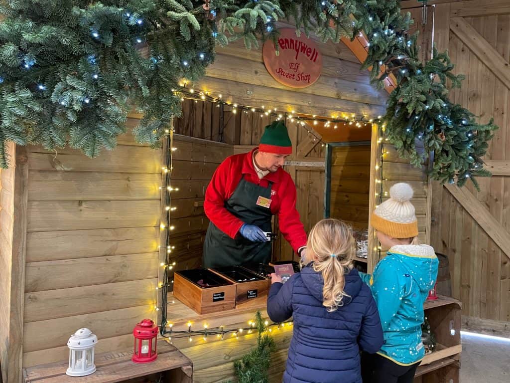 Kids being given sweets by an elf