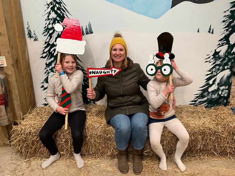 Family holding photo props in front of painted snowy scene