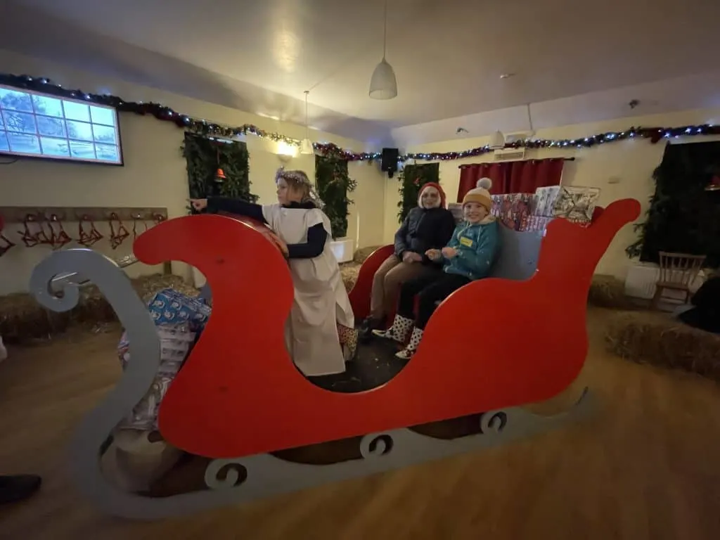 Children and grandparent sat in Santa's sleigh