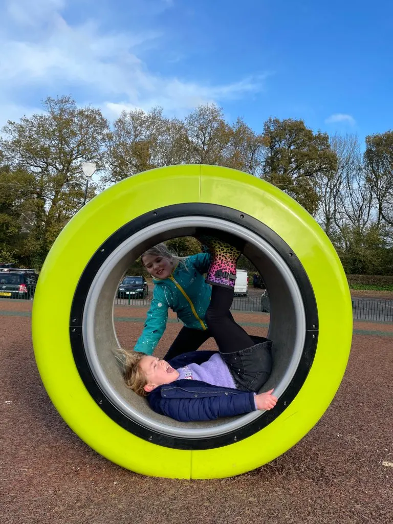 Children playing with wheel on playground at Decoy Country Park