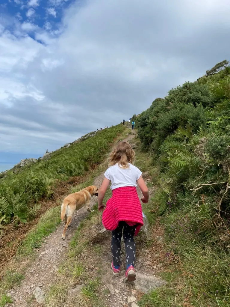 Child and dog walking up path in Valley of Rocks