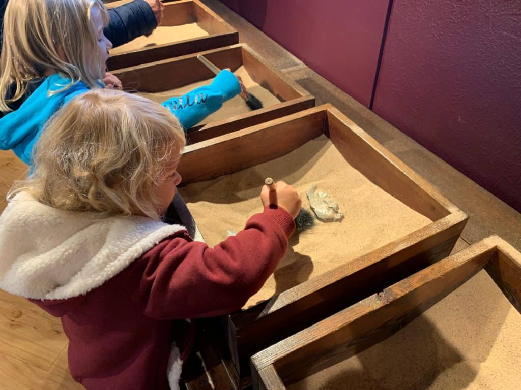 Children playing with sand filled excavation boxes