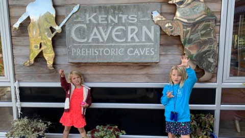 Children pretending to be pre-historic breast in front of Kents Cavern entrance