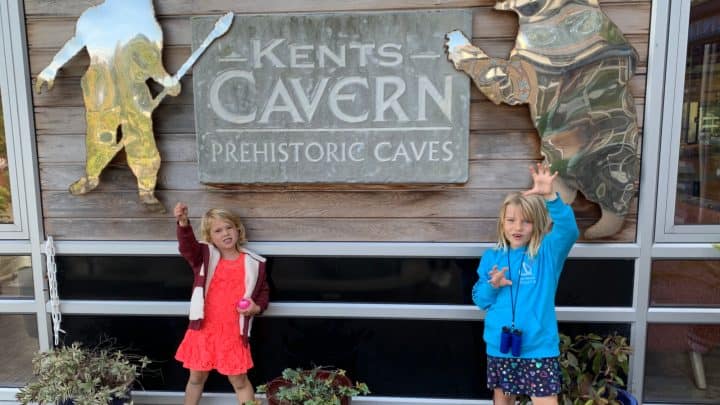 Children pretending to be pre-historic breast in front of Kents Cavern entrance