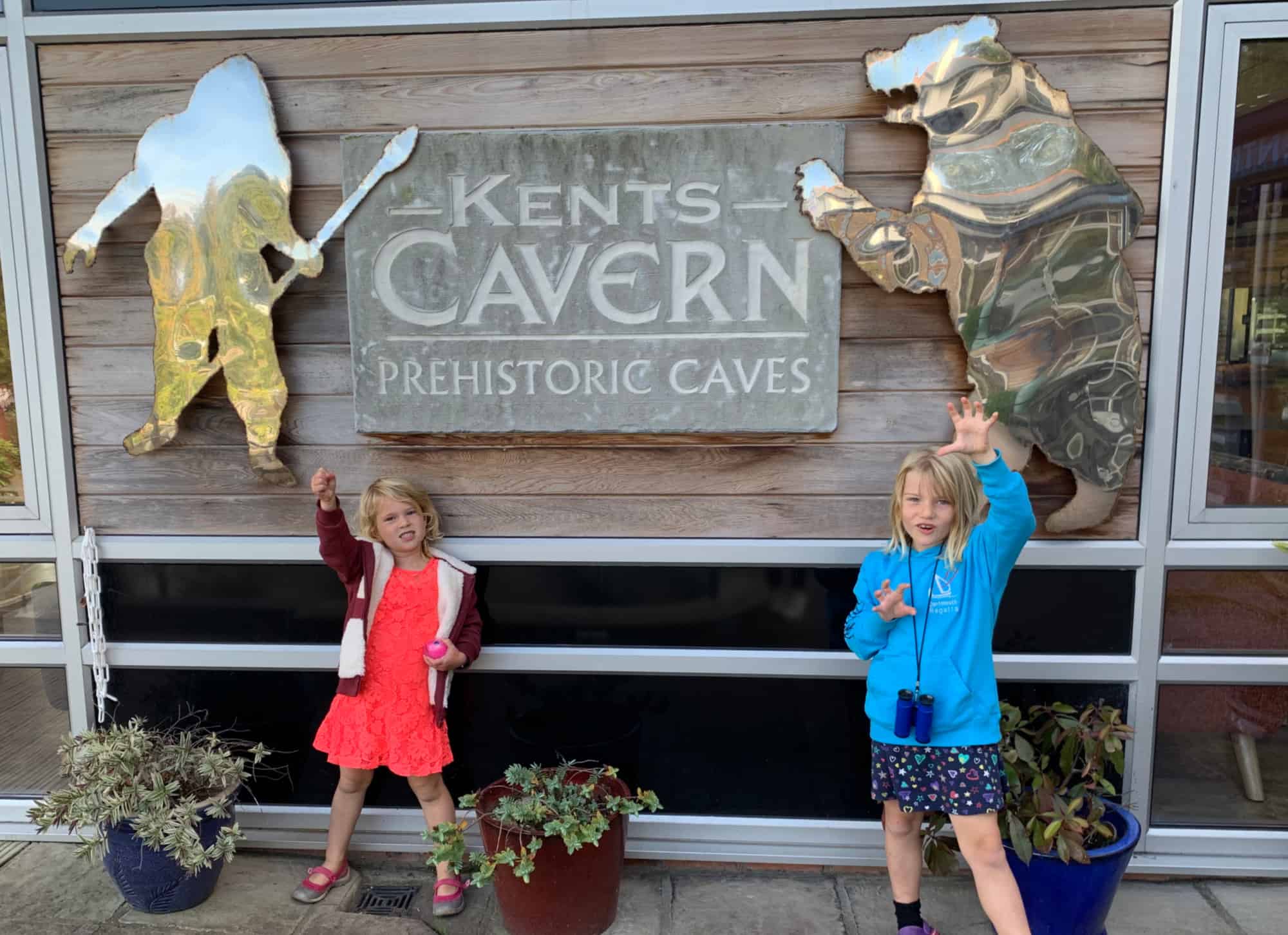 Children pretending to be pre-historic breast in front of Kents Cavern entrance