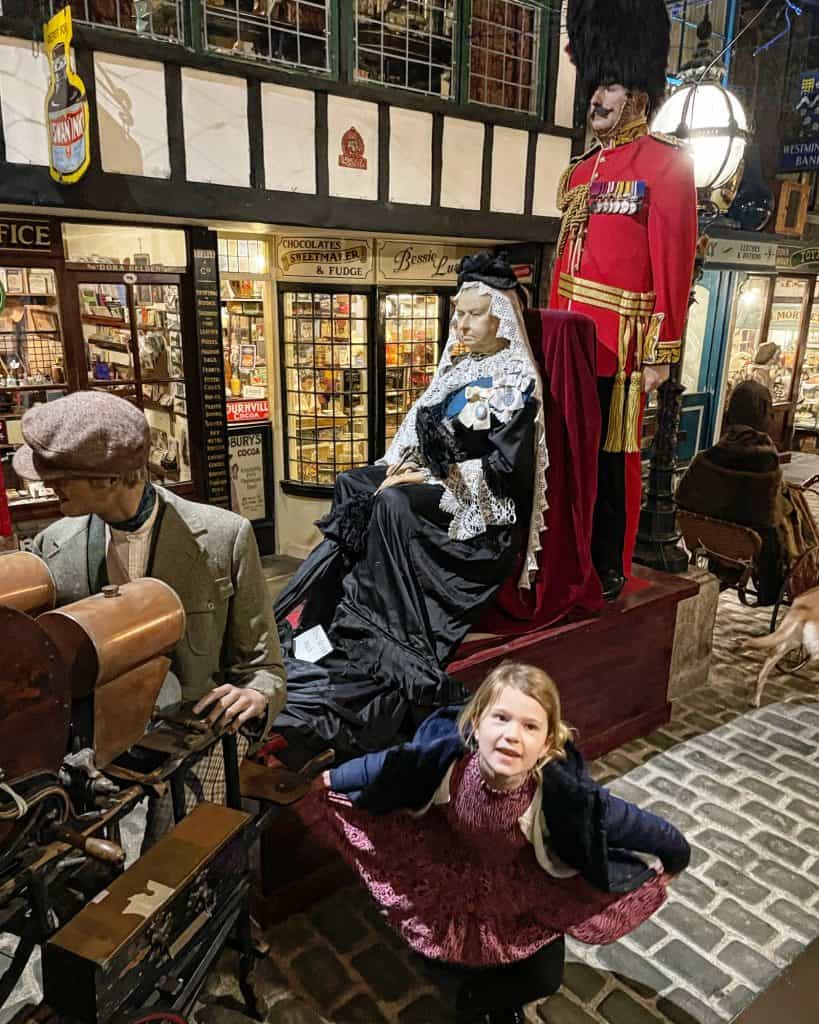Child curtsying in front of Queen Victoria mannequin