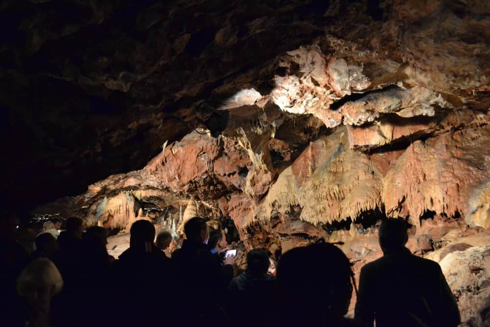 Visitors silhouetted against The Rocky Chamber at Kents Cavern