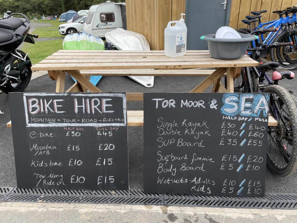 Chalk boards with prices for hiring bikes, kayaks and body boards